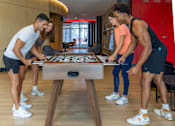 Thumbnail 5 of 27 - Four people playing a game of Foosball at Icon One, Daytona Beach
