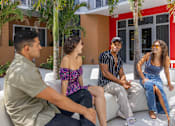 Thumbnail 15 of 27 - Four people sitting on a white couch outside a house.at Icon One, Daytona Beach, FL