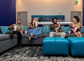 Thumbnail 20 of 27 - Three people are sitting on a couch eating popcorn and watching television.at Icon One, Florida, 32114