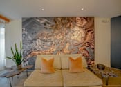 Thumbnail 63 of 72 - A bedroom with a large bed and a large painting on the wall.