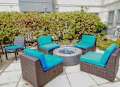 Thumbnail 29 of 72 - A patio with a fire pit and chairs.