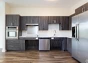 Thumbnail 53 of 72 - A modern kitchen with dark wood cabinets and stainless steel appliances.