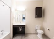 Thumbnail 51 of 72 - A white toilet sits next to a sink in a small bathroom.