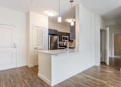 Thumbnail 50 of 72 - A kitchen with white cabinets and a wooden floor.