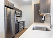 Thumbnail 49 of 72 - A kitchen with a stainless steel refrigerator, microwave, and sink.