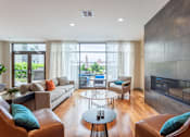 Thumbnail 10 of 72 - A modern living room with a fireplace and a glass table.