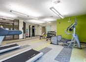 Thumbnail 34 of 72 - A gym with treadmills, weights, and exercise equipment.