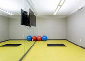 Thumbnail 37 of 72 - A room with a yellow floor and a television mounted on the wall.