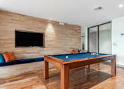 Thumbnail 11 of 72 - A pool table with a blue cloth and a television on the wall.