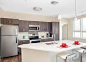 Thumbnail 48 of 72 - A modern kitchen with a white countertop and stainless steel appliances.