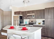 Thumbnail 47 of 72 - A modern kitchen with a white island and brown cabinets.