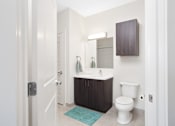 Thumbnail 64 of 72 - A white toilet sits in a bathroom next to a sink.