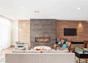Thumbnail 9 of 72 - A modern living room with a fireplace and a flat screen TV mounted on the wall.
