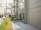 Thumbnail 23 of 72 - A modern building with a grey facade and a wooden deck.