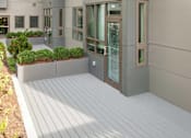 Thumbnail 22 of 72 - A modern building with a grey facade and a wooden deck.