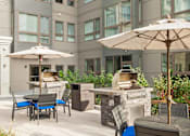 Thumbnail 26 of 72 - A patio with a table, chairs, and an umbrella.