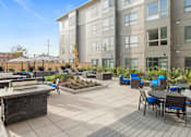Thumbnail 27 of 72 - A patio with a table and chairs is surrounded by a building and a fence.