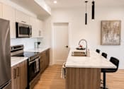 Thumbnail 15 of 24 - A modern kitchen with a marble countertop and stainless steel appliances.