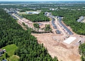 Thumbnail 11 of 20 - An aerial view of a construction site surrounded by trees and buildings.