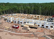 Thumbnail 14 of 20 - A large building under construction with a red truck parked in front.