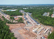 Thumbnail 12 of 20 - An aerial view of a construction site surrounded by trees.