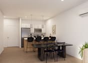 Thumbnail 18 of 20 - A modern kitchen with a dining table and chairs.