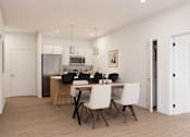 Thumbnail 6 of 20 - A modern kitchen with a dining table set for four.
