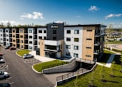 Thumbnail 24 of 24 - A modern apartment complex named "aknox" is surrounded by a parking lot and greenery.