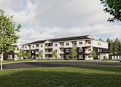 Thumbnail 2 of 20 - A large apartment complex with a grassy area in front.