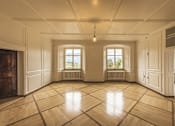 Thumbnail 3 of 12 - an empty living room with wooden floors and two windows