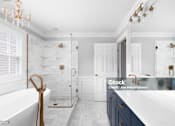 Thumbnail 5 of 12 - a white and blue bathroom with a tub and a shower and a sink
