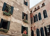 Thumbnail 1 of 12 - a woman looking out of a window of a building