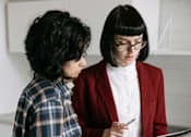 Thumbnail 4 of 15 - Two people in a laundry room, one holding a tablet.