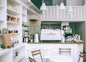 Thumbnail 10 of 15 - A white kitchen with a coffee machine and a blender.