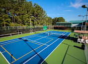 Thumbnail 10 of 12 - a tennis court with blue and green courts and a fence