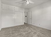 Thumbnail 11 of 12 - A room with a ceiling fan and a carpeted floor.