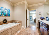 Thumbnail 5 of 21 - A bathroom with a large tub and a painting of a tree on the wall.