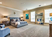Thumbnail 6 of 21 - A bedroom with a large bed and a couch.