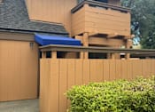 Thumbnail 24 of 41 - A house with a brown facade and a blue awning.