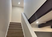 Thumbnail 27 of 41 - A staircase with wooden steps and white railings.