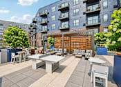Thumbnail 39 of 47 - A patio with a table and chairs is surrounded by apartment buildings.
