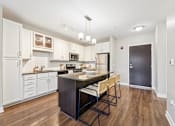 Thumbnail 4 of 45 - A kitchen with a dark wood floor and white walls.