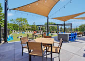 Thumbnail 37 of 46 - A patio with tables and chairs under umbrellas.