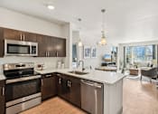 Thumbnail 3 of 33 - A modern kitchen with stainless steel appliances and wooden cabinets.