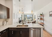 Thumbnail 4 of 33 - A modern kitchen with dark wood cabinets and a stainless steel dishwasher.