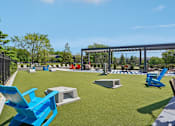 Thumbnail 31 of 46 - A park with blue chairs and a black fence.
