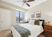 Thumbnail 10 of 45 - A bedroom with a bed, a ceiling fan, and a window with blinds.