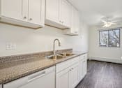 Thumbnail 1 of 24 - A kitchen with white cabinets and a granite countertop.