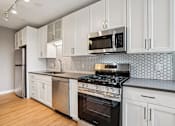Thumbnail 1 of 42 - Kitchen with white cabinetry and stove top oven at Arcata Apartments, Golden Valley, MN, 55416