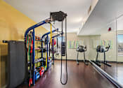 Thumbnail 38 of 45 - A gym with a variety of equipment including a cable machine.
